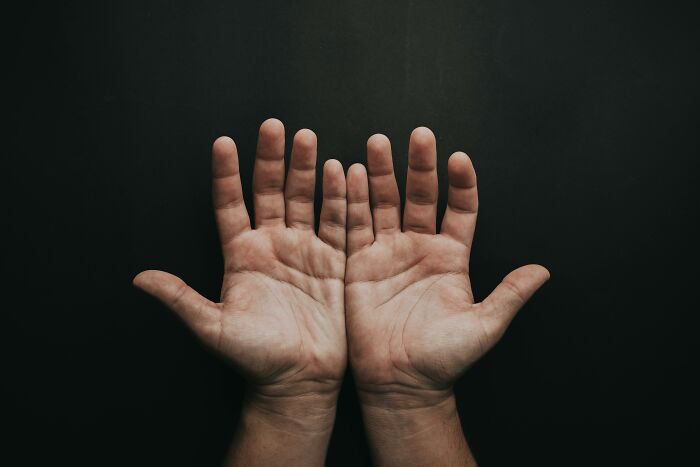 Two open hands against a dark background symbolizing the mystery and intrigue behind interesting mysteries that still baffle people.