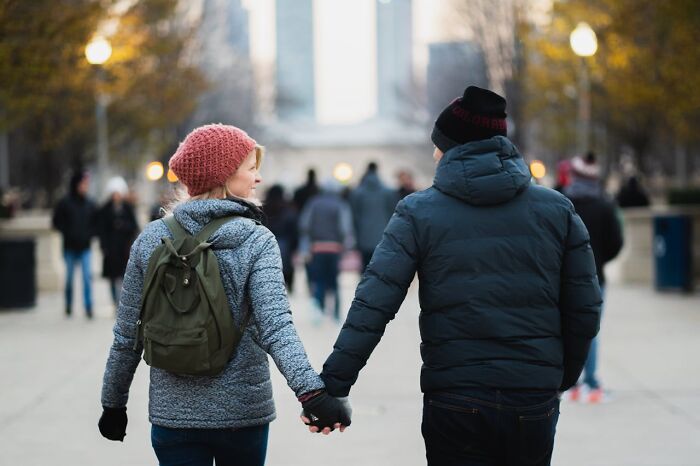 Two people holding hands outdoors in a city setting, illustrating toxic best friends and personal relationships. - 36