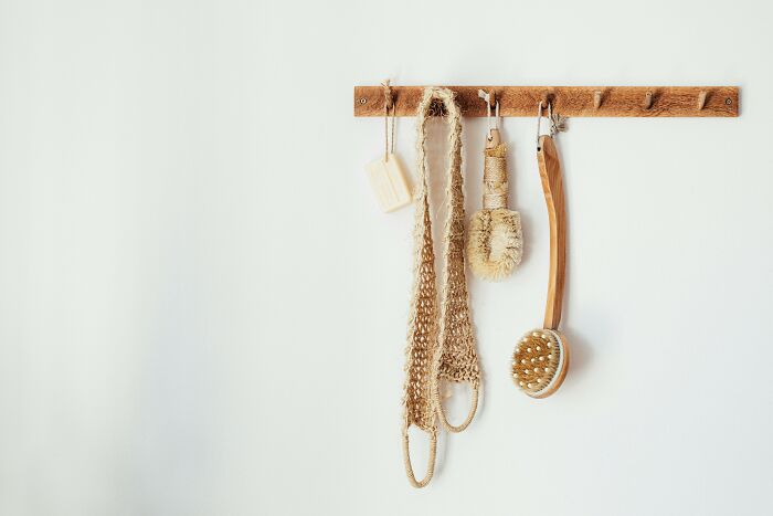 Natural fiber bath brushes and soap hanging on wooden hooks, showing things non-Americans do that confuse Americans. - 41