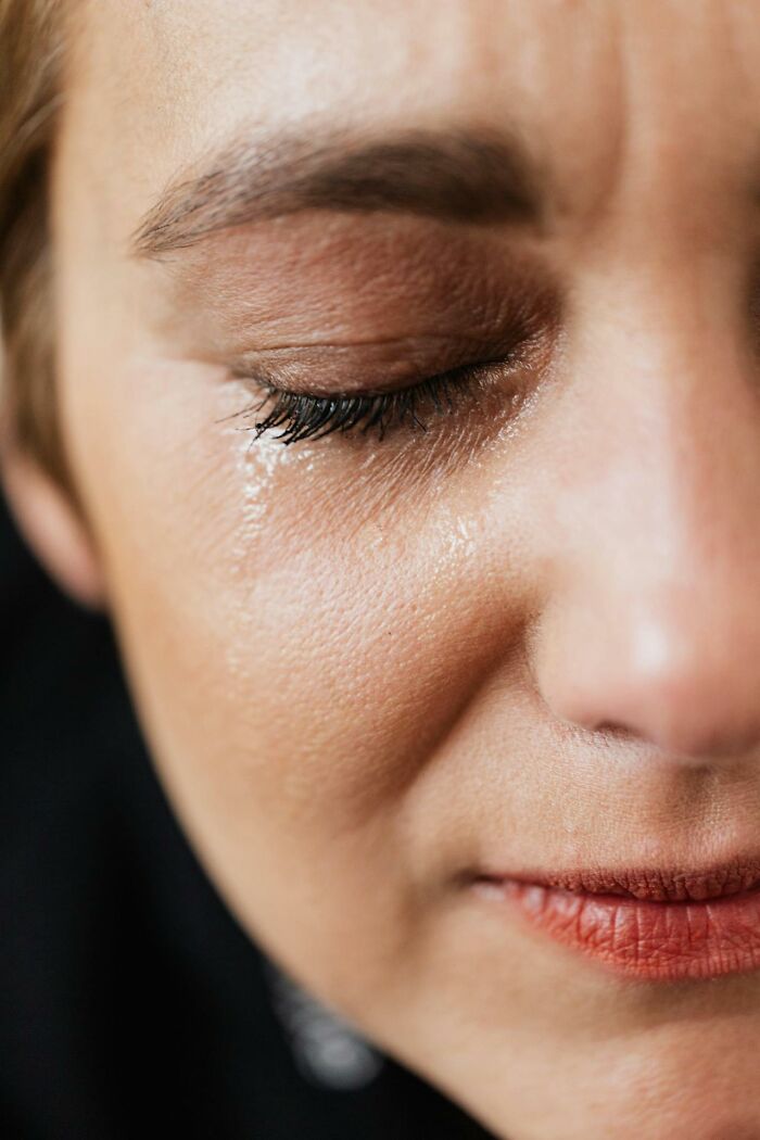Close-up of a tearful face with closed eyes, capturing the emotion of disturbing things people overheard say.