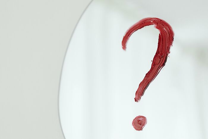 Red question mark painted on a mirror symbolizing true or false concept in a general knowledge challenge quiz.