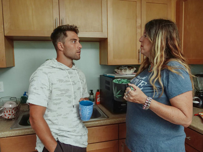 Young man and his mother in a tense kitchen conversation about relationships and family conflicts at home. - 19