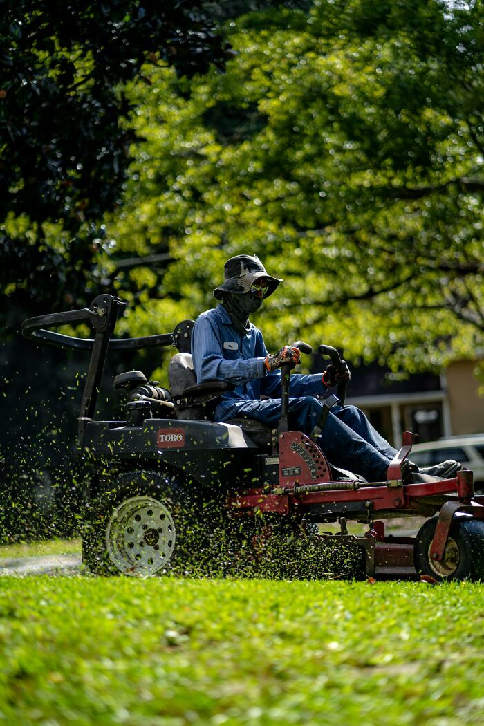 Lawn care professional operating a mower, showcasing a high-paying job that could help make 6 figures.
