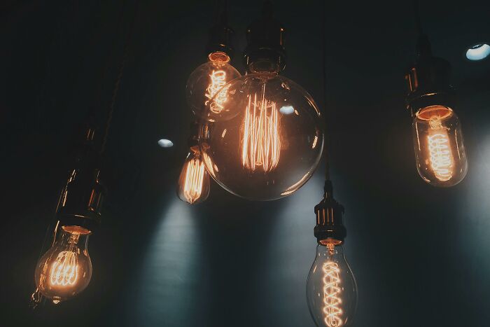 Hanging vintage light bulbs glowing warmly in a dark room, creating a cozy and inviting atmosphere for pickup lines.
