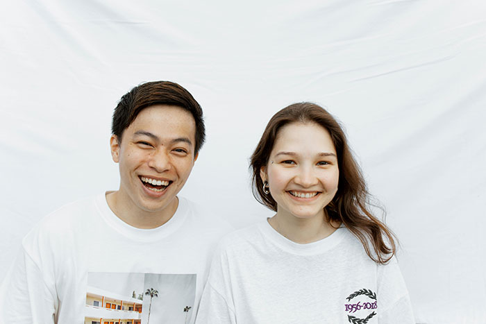 Smiling couple posing together against a white background, representing a wife obsessed with looking like an Asian child. Smiling couple posing together against a white background, representing a wife obsessed with looking like an Asian child.