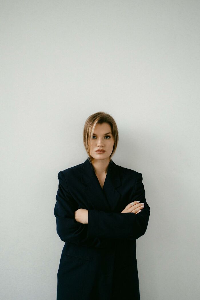 Young woman with serious expression stands with arms crossed, representing toxic best friends and emotional boundaries. - 19