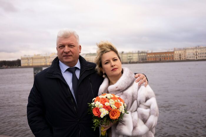 Older couple standing by waterfront, woman holding bouquet, illustrating life of older people after divorce experience. - 30