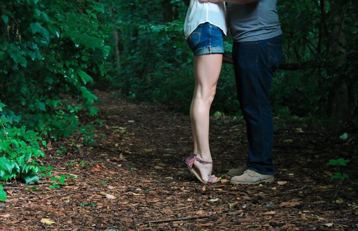 A couple standing closely on a forest path surrounded by greenery, illustrating toxic best friend relationships. - 47