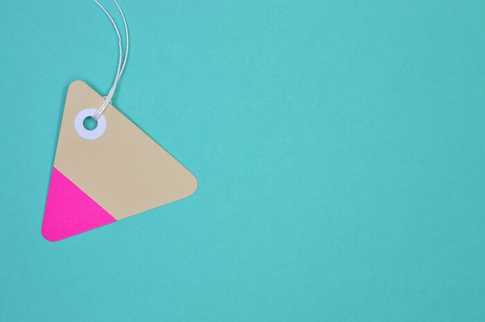 Triangle-shaped beige and pink price tag with string on a turquoise background, symbolizing pickup lines.