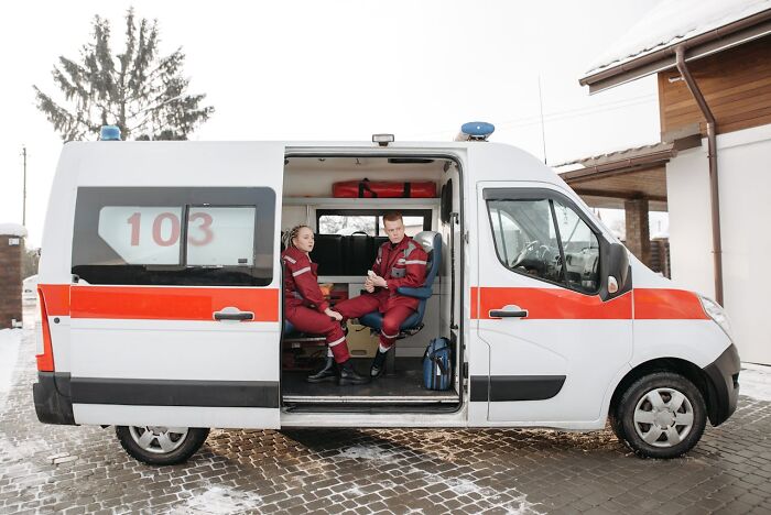 Two paramedics sitting inside an ambulance, ready to assist entitled patients demanding special treatment.