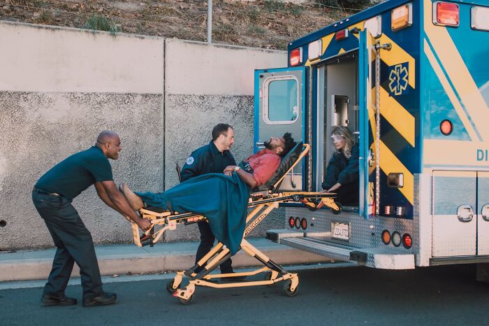 Paramedics loading injured man into ambulance, illustrating survival tips that won’t help you if followed incorrectly.