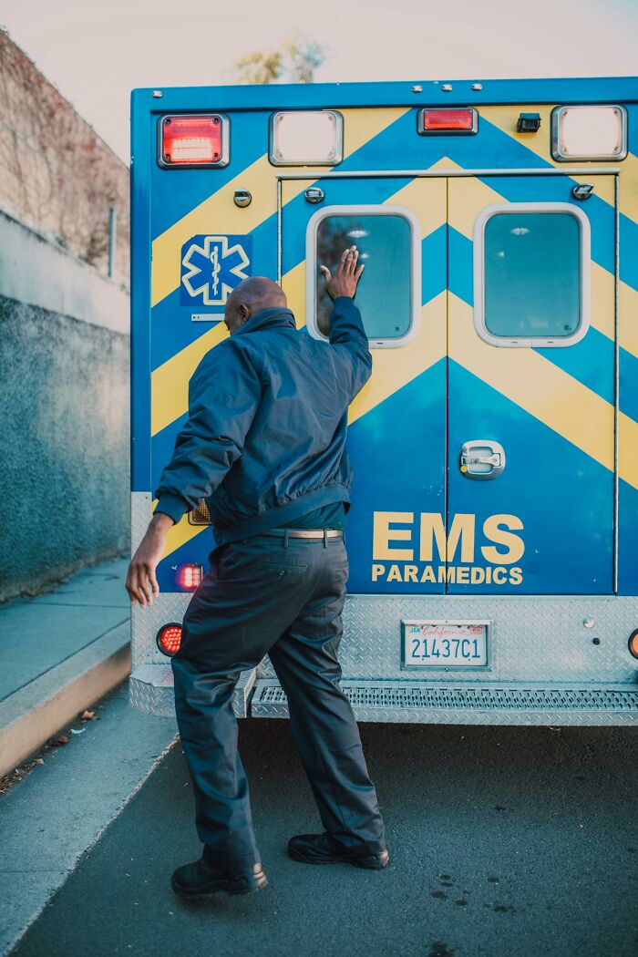 Man in uniform standing by EMS paramedics ambulance, illustrating survival tips and emergency response concepts.