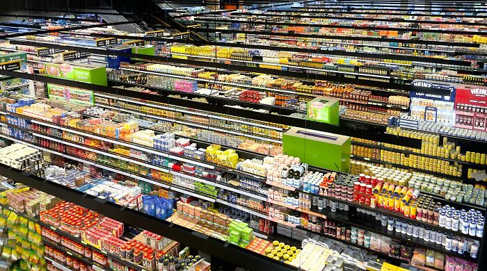 Supermarket shelves filled with packaged food items, highlighting the global food waste crisis and its impact.