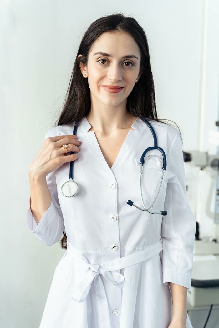 Young female doctor with a stethoscope around her neck smiling in a medical office, illustrating toxic best friends awareness. - 15