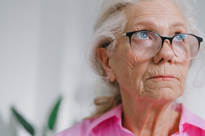 Elderly woman with glasses looking concerned, representing entitled patients demanding special treatment in a medical setting.