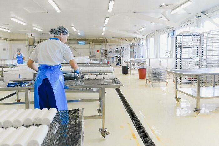 Worker in a food processing facility handling food packages highlighting the global food waste crisis environment.