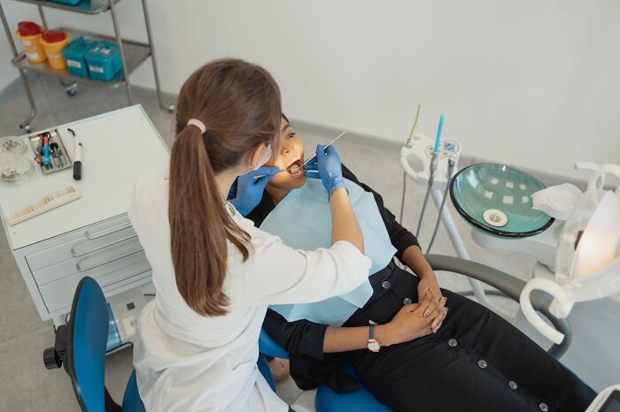 Dentist examining patient’s teeth in a modern dental clinic, representing high paying jobs to make six figures.
