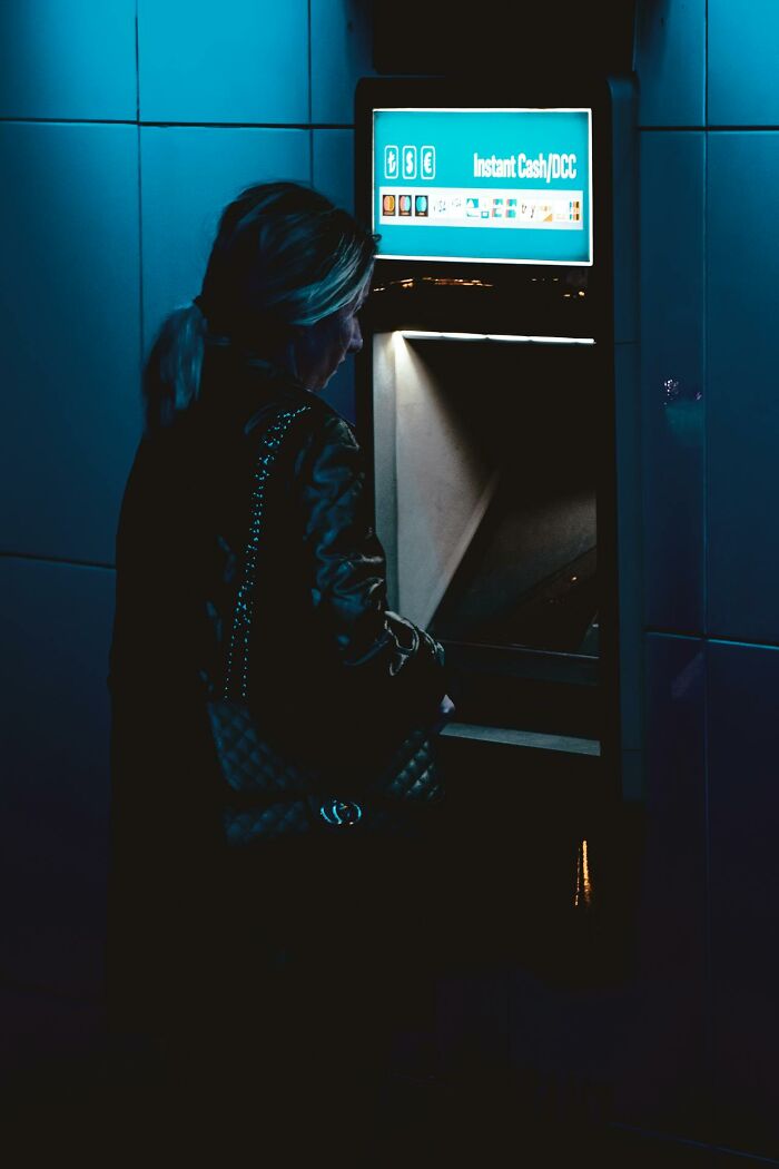Woman using ATM at night illustrating survival tips that won't help you in critical situations.