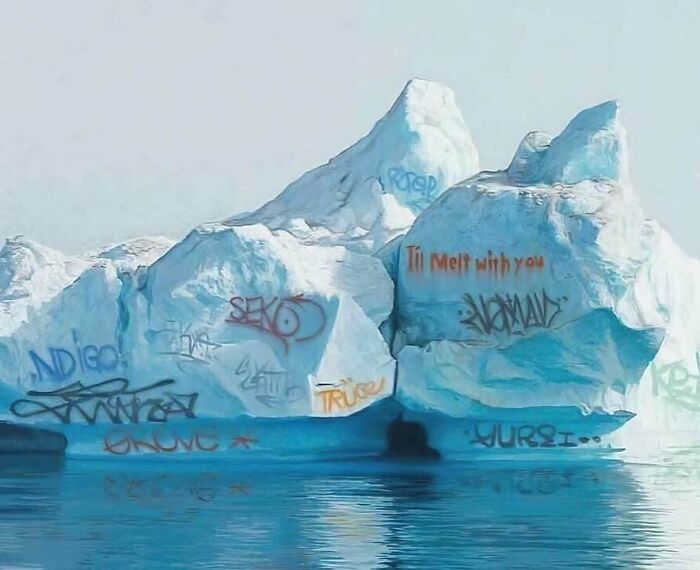 Iceberg covered in various graffiti art combining trash and culture in a chaotic urban style by the water.