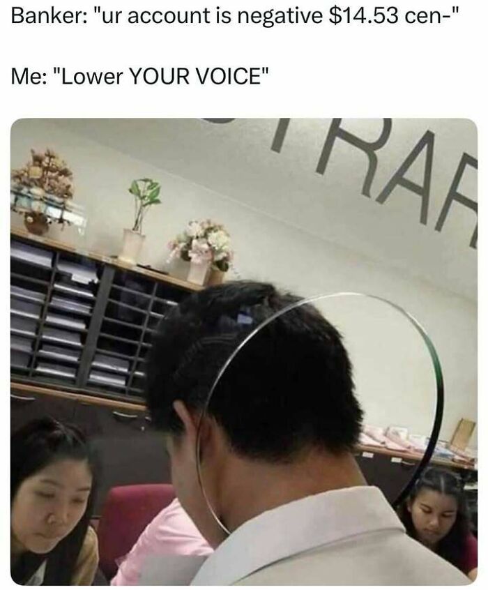 Person wearing a face shield in an office, reacting humorously to a banker mentioning a negative account balance meme.