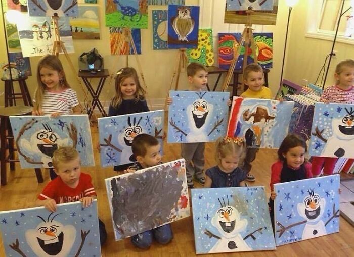 Children showing paintings of a snowman character in a colorful art classroom, blending culture and playful creativity.