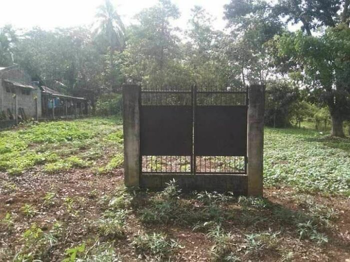 A gate installed in the middle of a field without any fencing, highlighting engineering mistakes in design.