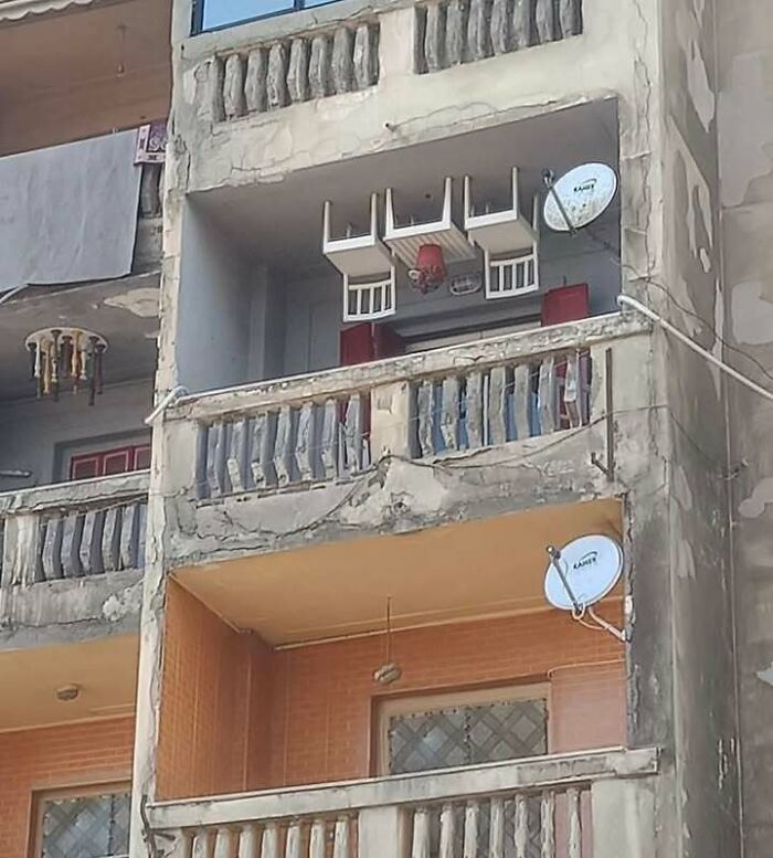 Balcony with upside-down chairs and lamp hanging from ceiling, showcasing chaotic and funny trash culture decor.