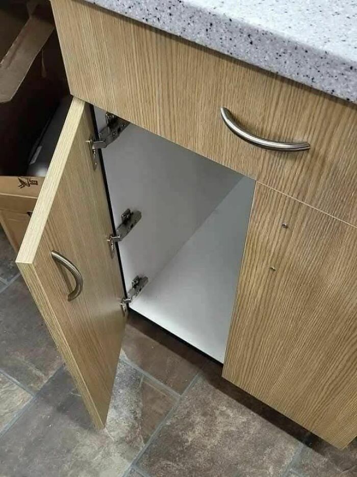 Wooden cabinet door installed with hinges inside the cabinet, a funny engineering mistake in construction.