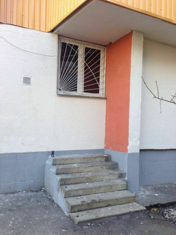 Concrete stairs leading to a window instead of a door, showcasing hilariously dumb engineering mistakes outdoors.