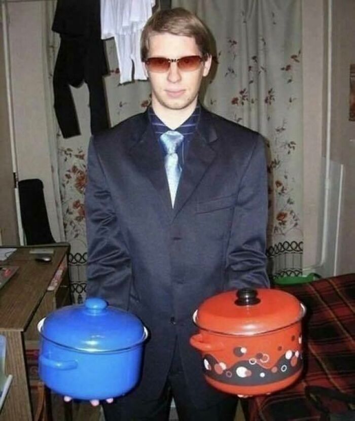 Young man in a suit and sunglasses holding two colorful pots, blending trash and culture in a chaotic and funny way.
