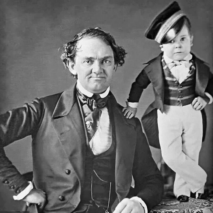 Vintage black and white portrait of a man and a small man in formal attire, unique old photos capturing rare moments.