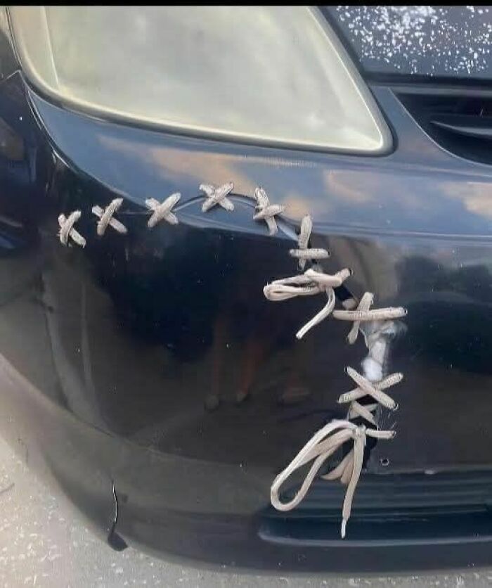 Car bumper patched with shoelaces in a hilariously dumb engineering degree mistake repair.