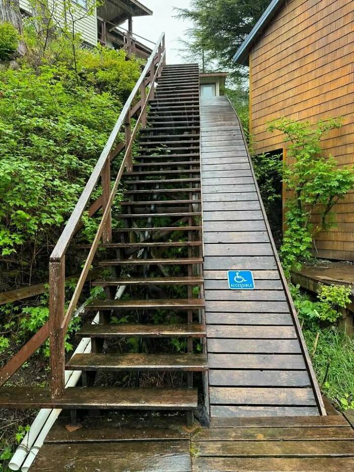 Wooden stairs with an inaccessible ramp labeled for wheelchair access, illustrating hilariously dumb engineering mistakes outdoors.