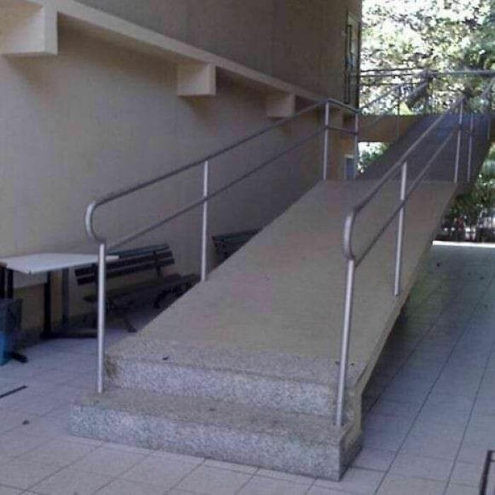 Concrete ramp with steps at the bottom showing a hilarious dumb engineering mistake in design and construction.