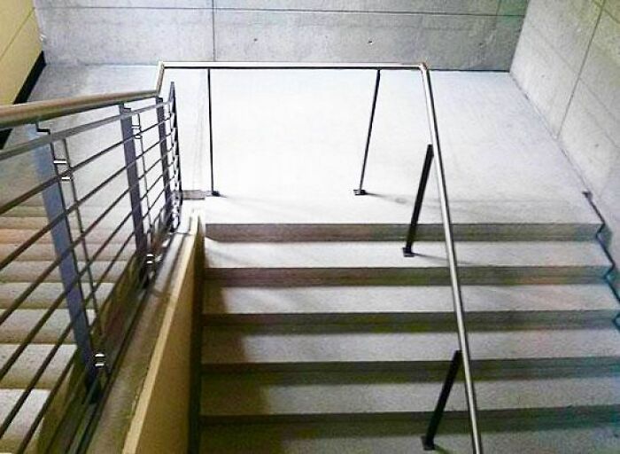 Staircase with missing safety railings creating a hazardous design error despite engineering knowledge.