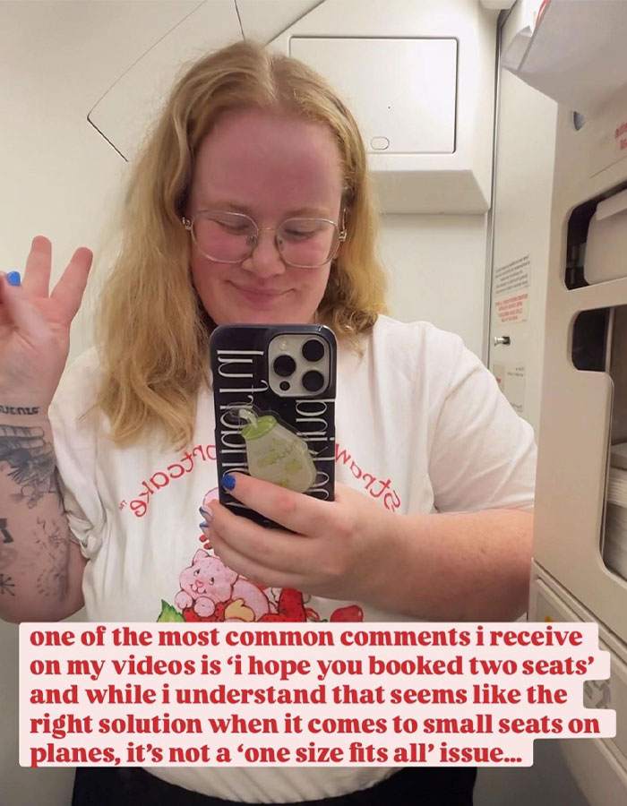 Plus-size traveler taking a selfie on an airplane, sharing her views on booking two airline seats and travel challenges.