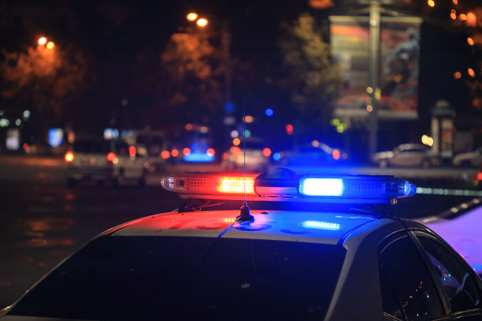 Police car with flashing red and blue lights at night, highlighting moments when gut feeling saved lives.