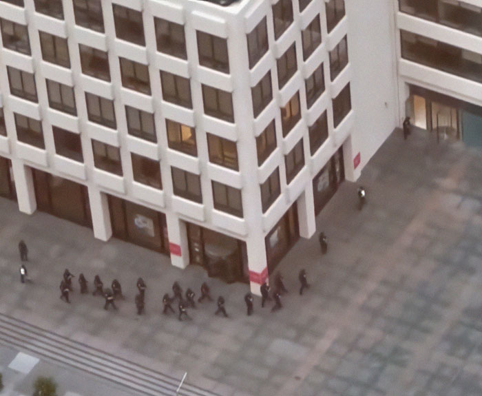 Group of NYPD officers walking outside a large urban building, related to NYPD cop fatally shot while protecting others.