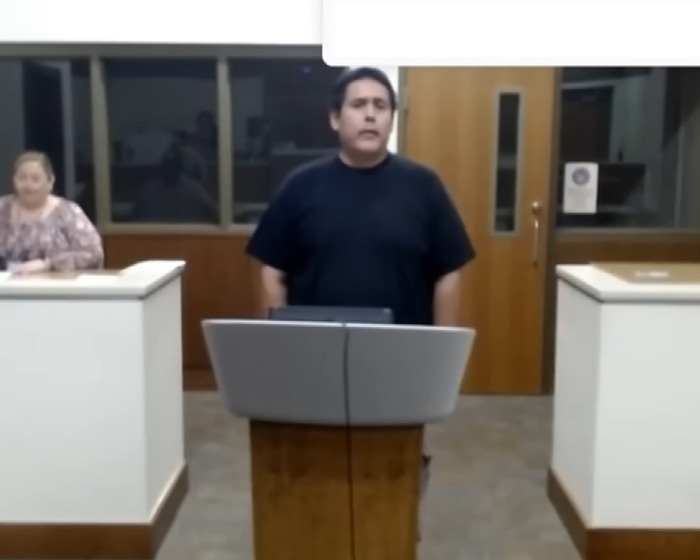 Man standing at a podium speaking to police about the rescue of 4 kids from a hot car while dad was intoxicated. - 8