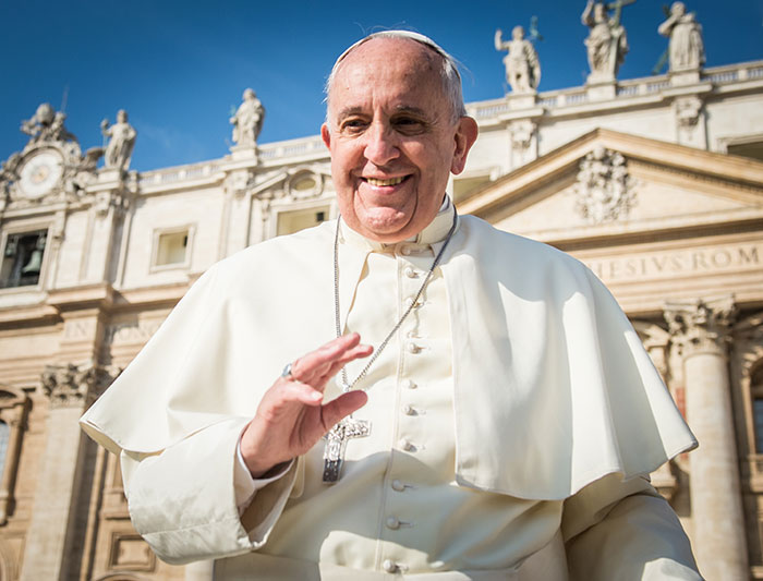 Smiling religious leader waving with historic building in background, representing stars we've lost this year.