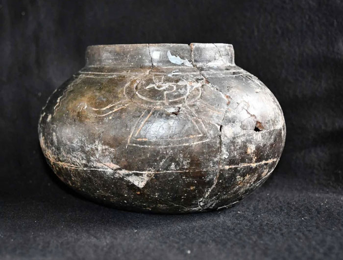 Ancient cracked black pottery vessel with carved designs, one of the priceless artifacts from Maya royal tomb discovery. - 9