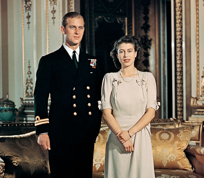 Prince Philip in uniform and Queen Elizabeth II in a dress posing together, representing royals who walked away from power.