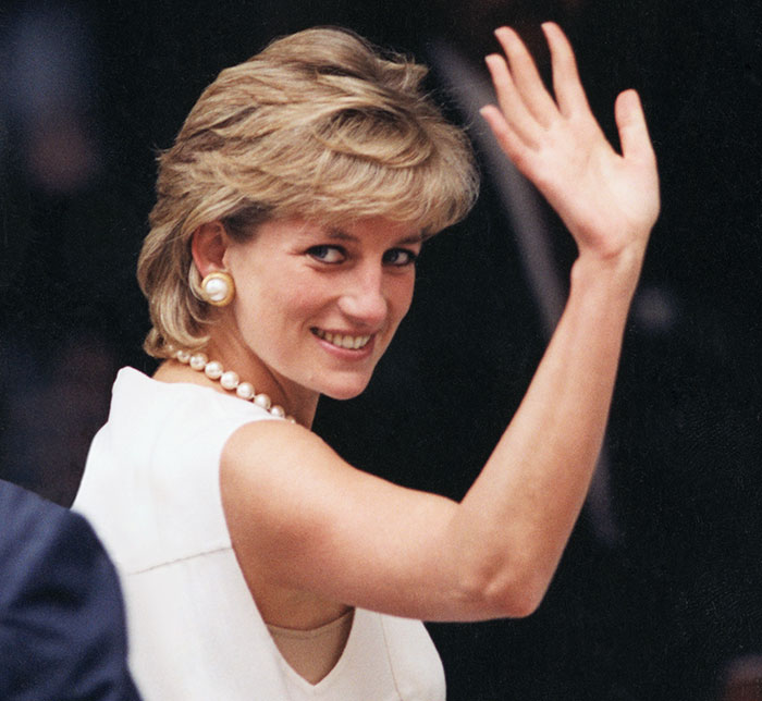 Princess Diana waving and smiling, an iconic royal who walked away from power for love and life-changing reasons.