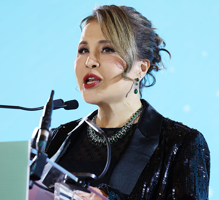 Woman speaking at a podium, representing royals who walked away from power for love and life-changing reasons.