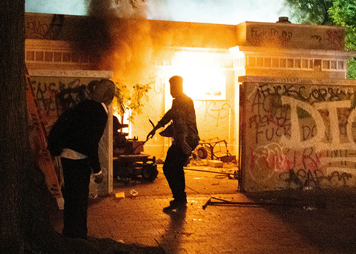 Two people near a fire in a graffiti-covered alley, illustrating strange things private investigators discovered on the job. - 32