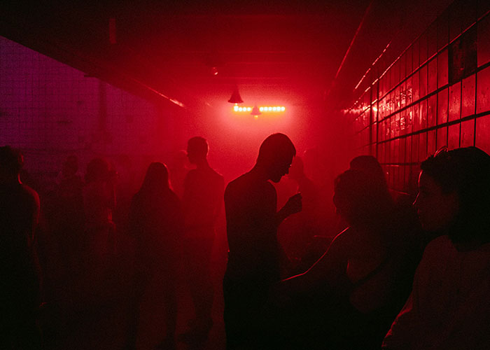 People silhouetted in a dimly lit red room, evoking the mysterious atmosphere of private investigators discovering strange things. - 12