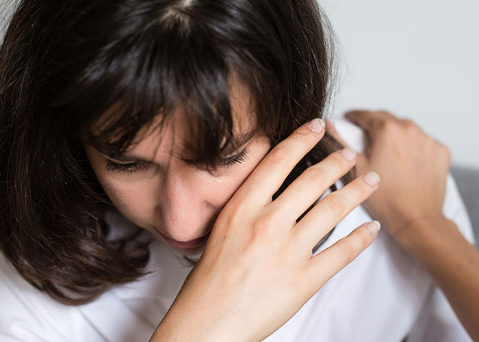 Woman covering her face with her arm showing emotions, related to strange things private investigators discovered during work. - 13