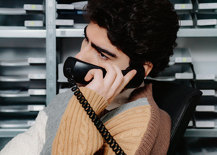 Young private investigator making a phone call while reviewing files, showcasing strange things discovered during investigations - 18