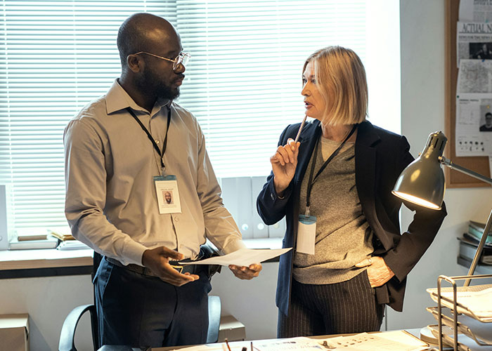 Two private investigators discussing case files in an office, showcasing strange things discovered during investigations. - 21