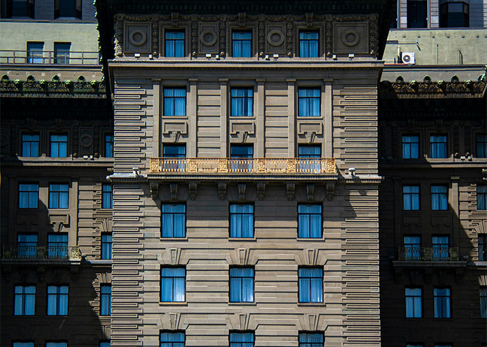Facade of an urban building with multiple windows, representing locations where private investigators discovered strange things. - 11